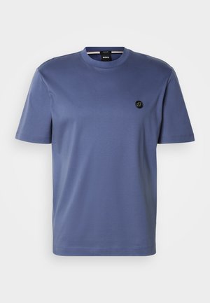 Korte mouwen T-shirt met ronde hals in gedempt blauw katoen, met een ronde zoom en een klein zwart logo op de borst. Gladde textuur, minimalistisch ontwerp.