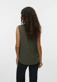 Top olive vert sans manches avec une coupe décontractée et un ourlet arrondi, fabriqué dans un tissu texturé. Le mannequin se tient de dos face à l'objectif, portant un jean foncé.