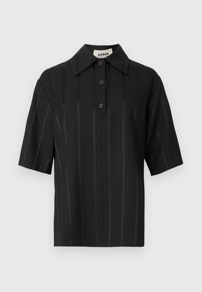 Camicia nera a maniche corte in tessuto liscio con sottili righe verticali, colletto appuntito e patta frontale con bottoni.