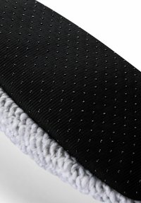 Czarna tkanina z fakturowanymi kropkami oraz jasnoszarym puszystym wykończeniem, charakteryzująca się gładką powierzchnią i zaokrąglonym kształtem. Kompaktowy design odpowiedni do różnych zastosowań.