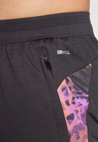 Schwarze Sportshorts mit einem Netzbund, einer Reißverschlusstasche und einem Seitenpanel mit einem abstrakten Muster in Lila und Pink.