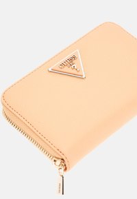 Portefeuille texturé pêche avec accent logo triangulaire doré, fermeture zippée et design aux bords lisses.