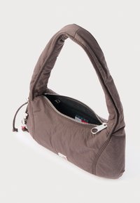 Brown nylon shoulder bag with a curved handle, zip closure, and a textured finish. Features a logo patch and a red accent at the zipper.