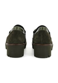 Scarpe in suede verde scuro con tacco nero lucido, dotate di una suola robusta e un accento cucito marrone attorno alla base.