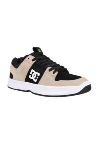 DC kengät beigessä ja mustassa nahassa valkoisella kumipohjalla. Varusteena mustat nauhat, logo sivussa sekä eroavat värikorostukset.
