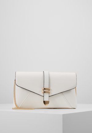Pochette en cuir blanc avec chaîne et boucle dorées, présentée sur un socle blanc sur fond gris uni.