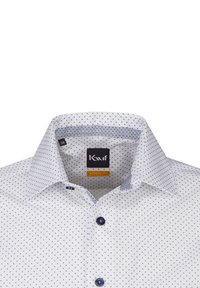 Chemise bianca con pois blu navy, colletto moderno, tessuto a contrasto nel colletto e nei polsini, due bottoni scuri.