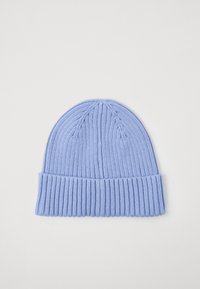 Gaiši zila adīta cepure ar vertikālu ribošanu un salocītu apmali, novietota uz balta fona.