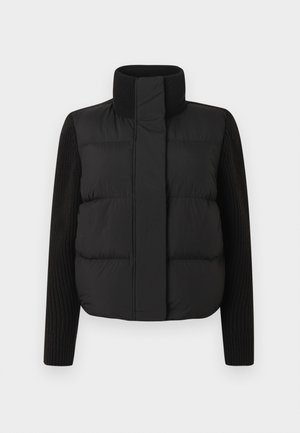 Juodas pūkinis švarkas su aukštu apykakliu, su paminkštinta priekiu ir megztomis rankovėmis. Lygi tekstūra, trumpas dizainas. Nėra matomų detalių.