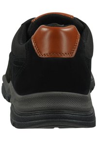 Zapatilla deportiva negra con un acento de tacón de cuero marrón y material texturizado negro, con una suela de goma para mayor tracción.