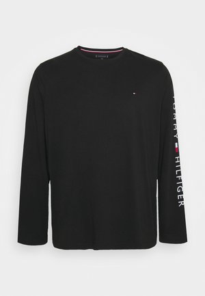 Schwarzes Langarm-T-Shirt aus weichem Stoff, mit Rundhalsausschnitt und dem Aufdruck "TOMMY HILFIGER" in Weiß entlang des rechten Ärmels.