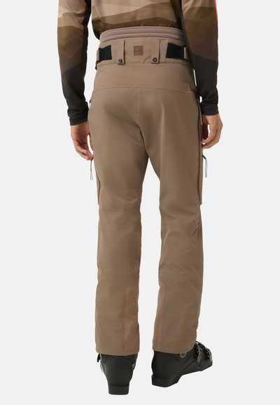 Braune Skihose aus glattem, wasserabweisendem Material. Ausgestattet mit Seitentaschen, verstellbarem Bund und artikulierten Knien für Beweglichkeit.