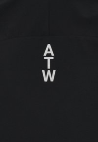 Czarna tkanina z pionowym układem liter "A", "T" i "W" w białym kolorze. Gładka tekstura z minimalnymi elementami designu.