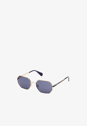 Gafas de sol octagonales con lentes oscuros, montura de metal dorado y puntas de varilla moradas. Presentan almohadillas nasales transparentes y acentos de diseño minimalista.