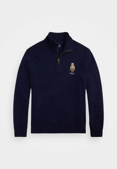 Pulôver azul marinho com colarinho de fecho de quartzo, feito de tecido suave. Apresenta um logótipo bordado e um design de personagem detalhado.