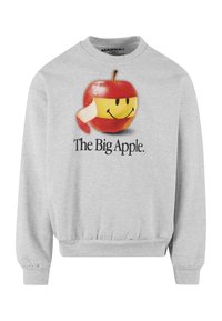 Grå sweatshirt med et stort grafik af et smilende æble iført et gult bånd, med "The Big Apple." trykt nedenfor i sort tekst.
