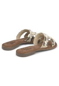 Sandales à glissière beiges ornées d'accents décoratifs en blanc et noir, avec une semelle intérieure texturée et une semelle en caoutchouc plate pour un confort optimal.