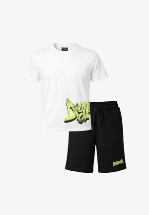 T-shirt bianca a maniche corte con testo giallo "Disclaimer" in stile graffiti vicino all'orlo, abbinata a pantaloncini neri con coulisse e piccolo logo giallo "Disclaimer".