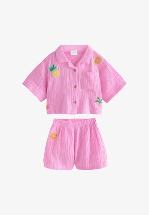 Ružová textúrovaná košeľa s krátkym rukávom na gombíky s náprsným vreckom a k tomu elastické šortky v páse, oboje vyšívané tropickými motívmi.