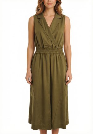 Vestido midi sin mangas de color verde oliva con escote en V, cuello, cintura elástica y bolsillos laterales, llevado por una mujer de pie con las manos relajadas a los lados.