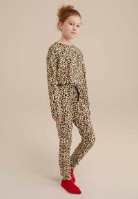 Pohodlný pyžamový set s leopardím vzorem v béžové barvě, obsahující dlouhé rukávy, stahovací pas a červené ponožky. Měkká tkanina s výraznými detaily vzoru.