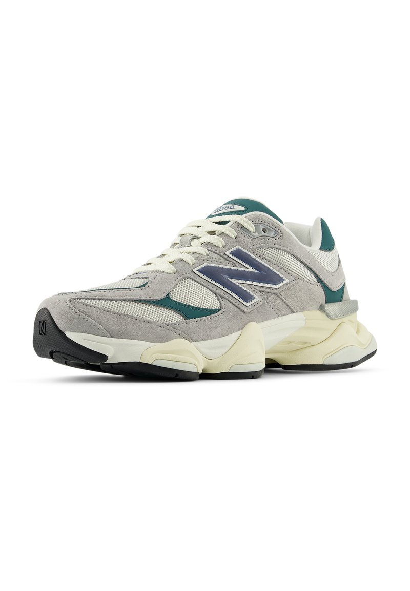 Light gray athletic shoe made of mesh and suede, featuring a green accent, prominent "N" logo, thick cream outsole, and beige laces.