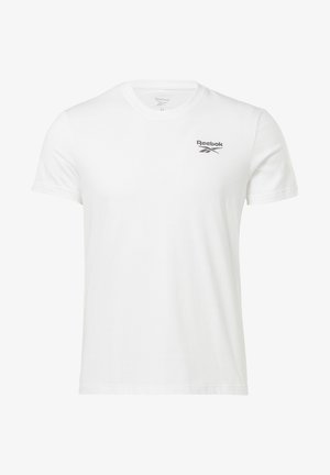 Bílé tričko s krátkým rukávem značky Reebok s klasickým kulatým výstřihem a malým černým logem Reebok na levé horní části hrudi.