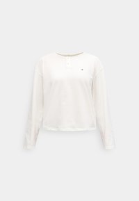 Balta kokvilnas krekls ar garām piedurknēm, ar Henlē tipa kakla izgriezumu ar divām pogām un mazu logotipu kreisajā krūtīs.