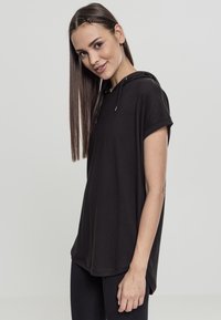 Svart kortärmad hoodie med en lös passform, tillverkad av mjukt material. Har en huva med dragsko och en rundad nederkant för en avslappnad look.