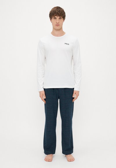 Top blanco de manga larga con el logo "POLO", combinado con pantalones a cuadros azul oscuro con un patrón de rejilla. Tela de mezcla de algodón, corte relajado.