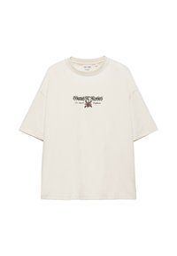 T-shirt blanc cassé à manches courtes avec le texte « "Guns N' Roses Los Angeles California" » et un petit motif de rose au centre devant.