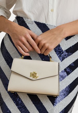 Borsa a tracolla in pelle avorio con dettagli in oro, dotata di chiusura a pattella e logo inciso. Abbinata a una gonna a righe di paillettes.