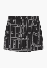 Černá sukně s liniovým bílým vzorem a nápisem "CALVIN KLEIN JEANS". Vyrobena z měkké tkaniny, má čistý střih a boční kapsu.