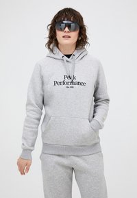 Grå hættetrøje med frontlomme og trykt tekst "Peak Performance Est. 1986" i sort. Blødt tekstureret stof, afslappet pasform.