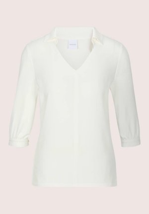 Wit shirt met lange mouwen, V-hals en kraag, nauwsluitende stijl en met knopen gesloten manchetten op een lichte achtergrond.