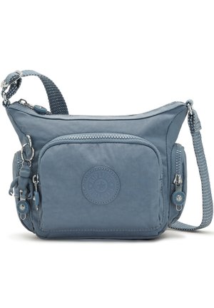 Sac bandoulière en nylon bleu avec plusieurs compartiments zippés, une sangle réglable et une petite figurine porte-clés attachée à la tirette de la fermeture éclair latérale.