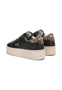 Baskets en cuir noir avec un accent en imprimé léopard texturé sur le talon et une semelle plateforme beige. Présentent des lacets métalliques.