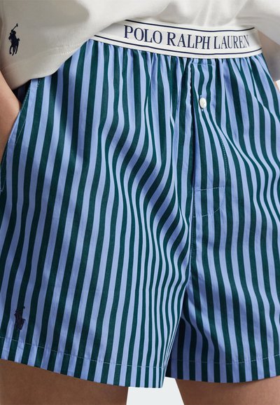 Niebiesko-zielone spodenki w paski z białym elastycznym paskiem w talii z napisem "POLO RALPH LAUREN". Posiadają guzik oraz małe logo.
