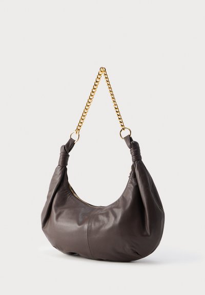 Σκούρο καφέ δερμάτινη τσάντα ώμου με χρυσή αλυσίδα χειρολαβής και φερμουάρ κλεισίματος, παρουσιάζεται σε απλό ανοιχτό φόντο.