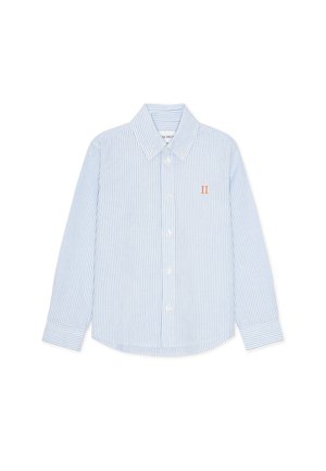Camicia a maniche lunghe a righe azzurro chiaro e bianco. Presenta un colletto con bottoni, bottoni frontali e un piccolo emblema arancione sul petto.