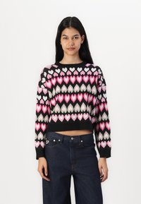 Kort genser med svart bakgrunn og fargerike hjerte mønstre i rosa, hvitt og grønt; ribbestrikket mansjetter og hem.