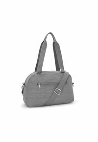 Bolso de tela gris con dos asas superiores y una correa de hombro ajustable. Presenta un bolsillo frontal con cremallera y una superficie lisa, ligeramente texturizada.