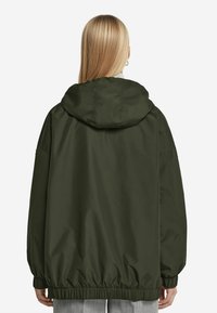 Grön huvtröja med elastiska muddar och nederkant, med en slät yta och avslappnad passform, designad för komfort och värme.