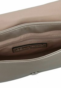 Bolso de mano beige con un exterior sintético suave y un interior de satén. Cuenta con un bolsillo con cremallera y un cierre a presión. Etiqueta de la marca visible en el interior.