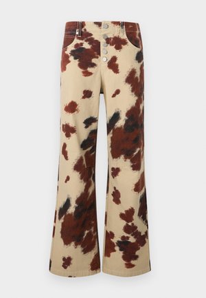 Pantaloni largi cu talie înaltă, imprimeu de piele de vacă maro și negru, închidere frontală cu nasturi și buzunare frontale vizibile, pe un fundal simplu.