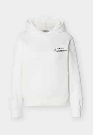 Valge kapuutsiga pikka varrukaga dressipluus, mille vasakul rinnal on must tekst "GANT American sportswear New Haven".