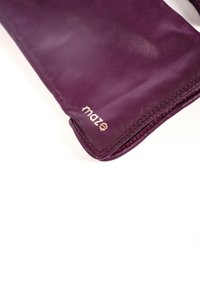 Lederhandschuh in tiefem Purpur mit feiner Textur. Die Ränder sind in kontrastierendem Rot vernäht. Am Handgelenk befindet sich ein goldgeprägtes Logo.