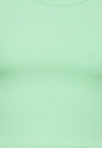 Camisola de alças em verde menta, com um decote redondo e um design ajustado, feita de um tecido elástico suave.