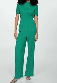 Groen twee-delig outfit van ribbelstof, met een top met korte mouwen en wijde broek, met een gestructureerd patroon overal.