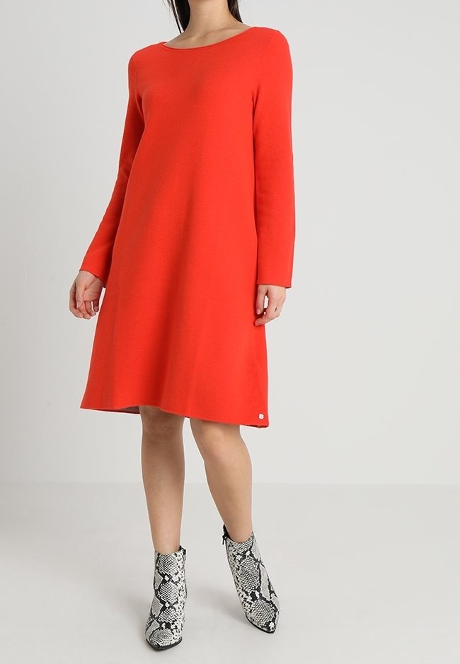 Rotes Langarmkleid mit U-Boot-Ausschnitt, aus glattem Stoff gefertigt, mit gerader Schnittführung, kombiniert mit gemusterten Schlangenleder-Ankle-Boots.